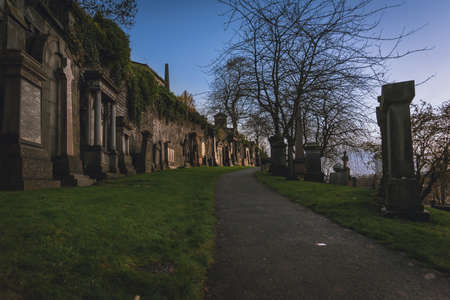 GLASGOW, SCOTLAND, DECEMBER 16, 2018: path to enter to the Glasgow Necropolis, surrounded quietly by lots of tombstones aside, shaping the wayのeditorial素材