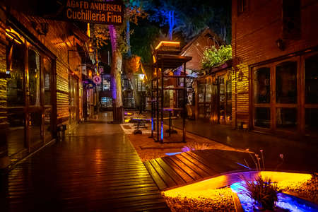 Outdoors shops gallery at night with nobody around, illuminated with different coloursの写真素材