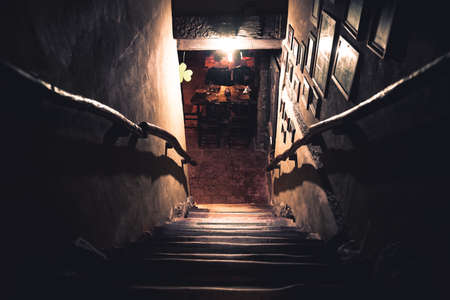 Dramatic point of view of scary stairs from upside into darkness of interior of old pubの写真素材
