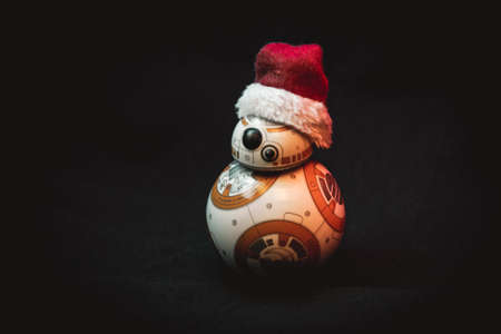 CABA, ARGENTINA, NOVEMBER 28, 2020: Lovely droid BB-8 from Star Wars, wearing a Christmas hat in dark background illuminated by colorful lightsのeditorial素材
