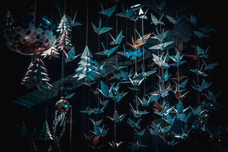 Lots of origami swans hanging from the roof, seen from underneath in a softly illuminated roomの写真素材