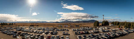 BARILOCHE, ARGENTINA, JUNE 22, 2019: Panoramic view of crowded airport car parking with lots of vehicles on a sunny day with mountains over the horizon.のeditorial素材