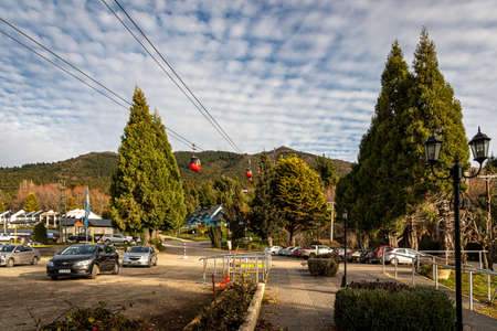 BARILOCHE, ARGENTINA, JUNE 19, 2019: Red cable car carrying passengers to the top of snowy mountains seen in the background.のeditorial素材