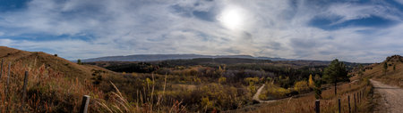 Panoramic view of an unpaved road through the landscape of San Miguel de los Rios forests in Cordoba, Argentinaの写真素材