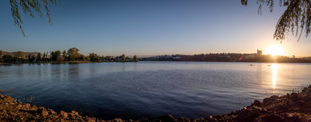 Panoramic view of Saint Roque Lake in Villa Carlos Paz at sunset while people enjoy rowingの写真素材