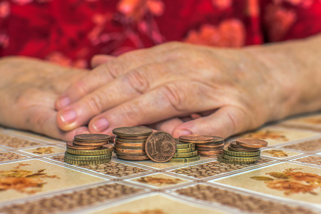 Old people often have financial problems. You have to count on every penny. Hands of an old woman (65-80 years) with the wherewithal. Concept: Money (EURO)の写真素材