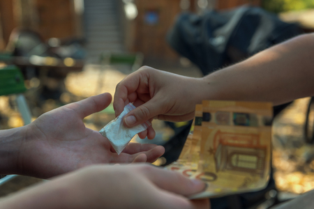 On a children's playground someone buys and sells drugs. Concept: abuse or addictionの写真素材