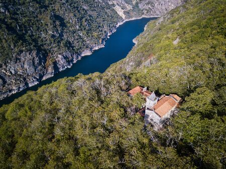 Aerial view of Santa Cristina de Ribas de Sil in early Autumn, with the canyon of the river Sil acting as the natural border between the provinces of Ourense and Lugo in the Ribeira Sacra in the background.の写真素材