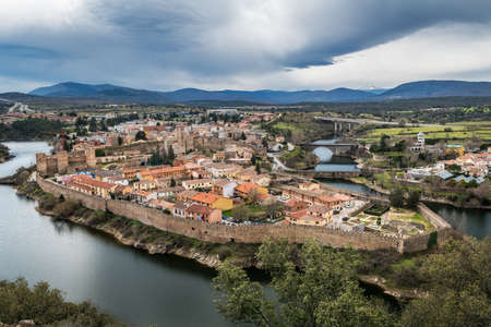 Aerial view of Buitrago del Lozoya, a well preserved historic village near Madrid, surrounded by the Lozoya river, with the Guadarrama mountain chain and reservoir in the background.のeditorial素材