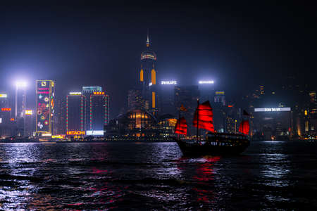 HONG KONG - DECEMBER 8, 2013: Illuminated Chinese red junk (Aqualuna) on Victoria Harbour, Hong Kong, on a foggy Winter night.のeditorial素材