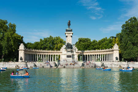 Madrid, Spain - May 30, 2015: Tourists and locals enjoy the Summer heat rowing in the main pond and resting under the monument to Alfonso XII at the Retiro Park (Parque del Buen Retiro) in Madrid, Spain.のeditorial素材