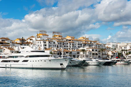 Marbella, Spain - October 13, 2016: White expensive luxury yachts moored in the marina of Puerto...