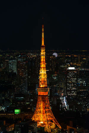 Cityscape of Tokyo at night, as seen from the top of one of the highest buildings in Roppongi Hills, with the illuminated Tokyo Tower glowing in the dark. Long exposure.のeditorial素材