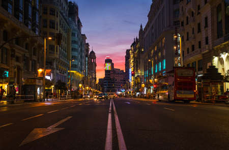 MADRID - AUGUST 4, 2016: Low-angle view of Madrid's busy Gran VÃ­a street at dusk, with Callao and...
