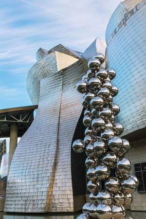 BILBAO, SPAIN - JANUARY 20, 2016: Detail of the back side of the Guggenheim Museum on the bank of the Nervion river in Bilbao, with the sculpture of a spider by Louise Bourgeois in the foreground. Detail of the back side of the Guggenheim Museum on the baのeditorial素材