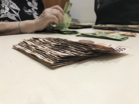 Woman ordering mexican pesos into different piles