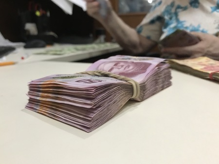 Some mexican peso money bills stacked on a beige coloured tableの写真素材