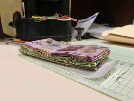 Many mexican pesos bills over a desk inside a small business officeの写真素材