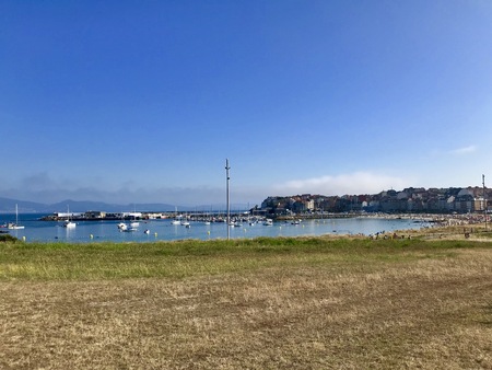 View of a field with dry grass and the beach during a beautiful summer day in Sanxenxo Galicia Spainのeditorial素材