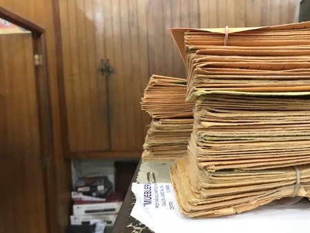 Many stacked yellow envelopes separated into packages with rubber bandsのeditorial素材