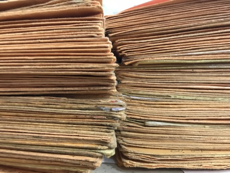 Many stacked yellow envelopes separated into packages with rubber bandsの写真素材