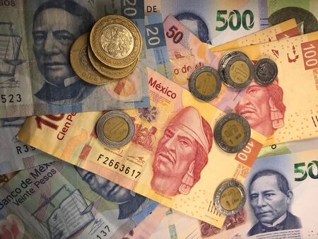Many mexican pesos bills spread randomly over a flat surfaceの写真素材