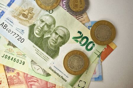 Many mexican pesos bills spread randomly over a flat surfaceの写真素材