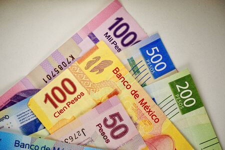 Many mexican pesos bills spread randomly over a flat surfaceの写真素材