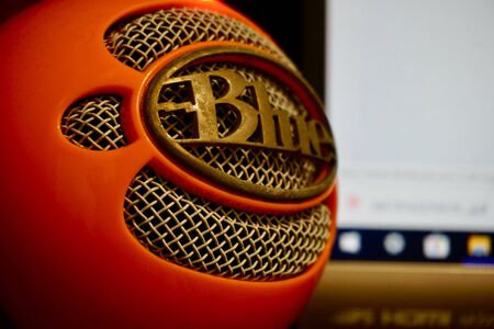 Puebla, Puebla / Mexico - December 15 2019: Editorial illustrative close up view of an orange colored Blue Snowball USB microphone with a computer monitor in the backgroundのeditorial素材