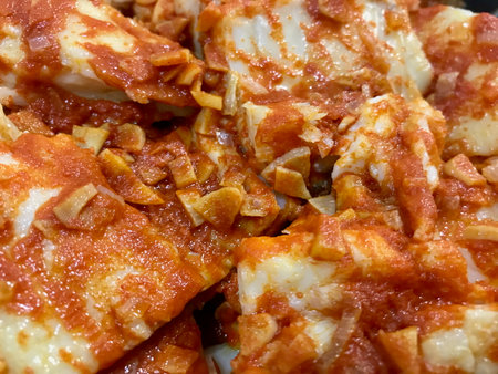 Close-up of Bacalao a la VizcaÃ­na, a traditional Spanish cod dish in rich red pepper sauce.