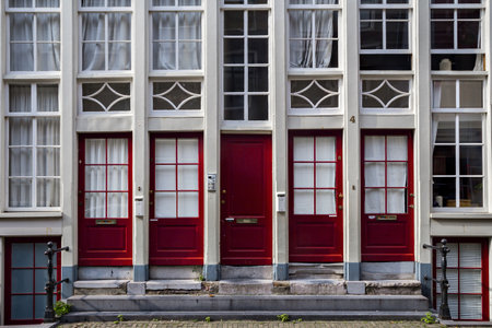 Parallel red doors in Amsterdam, multiple entranceの写真素材