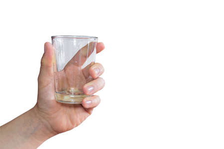 A white hand holding an empty wet glass on a white backgroundの写真素材