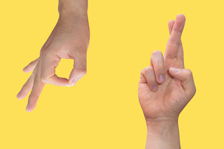 Two white hands making different shapes on a yellow background