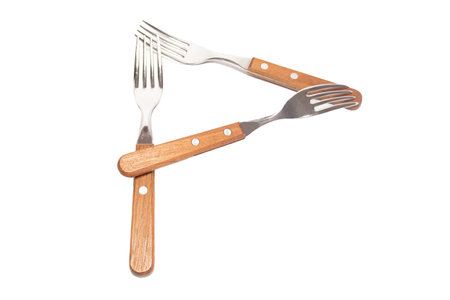 3 forks with wooden handles making the letter P on a white backgroundの写真素材