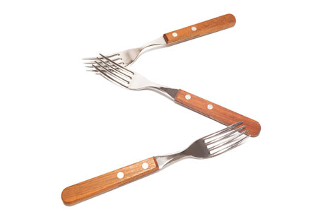 3 forks with wooden handles making the letter S on a white background