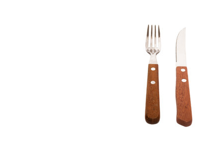 A knife and a fork with a wooden handle isolated on a white background with space for textの写真素材