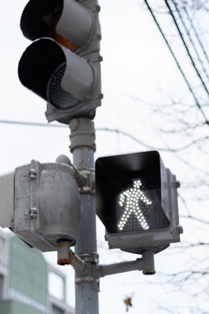 Close up to a traffic light with the pedestrian go signal onの写真素材
