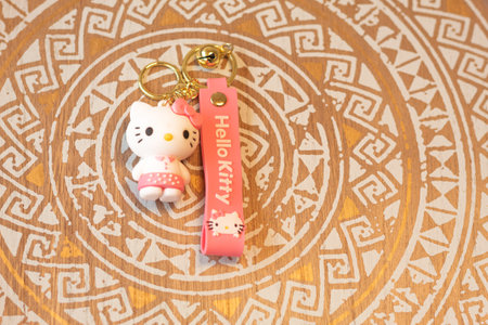 BogotÃ¡, Colombia - December 22, 2022: A Hello Kitty keychain on a wooden background with a madala designのeditorial素材