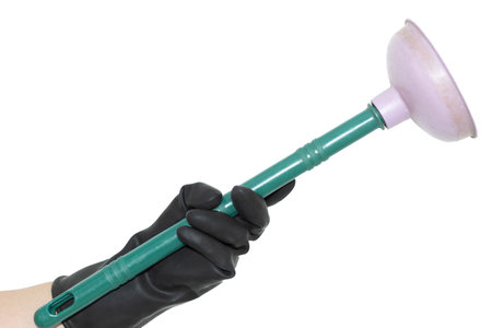 An isolated hand in a black rubber glove holding a plunger on a white background. Hand of a cleaner.の写真素材