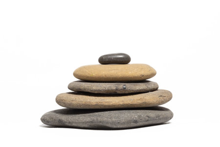A stack of five flat rocks sorted by size isolated on a white background. Zen.