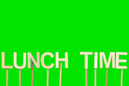 Lunch time sign made with individual wooden letters on a green chroma background.の写真素材