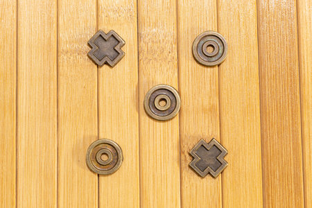 Copper tic tac toe game on a wooden backgroundの写真素材