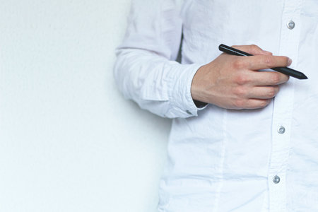 A businessman holding a pen close to his body, image with copy space.の写真素材