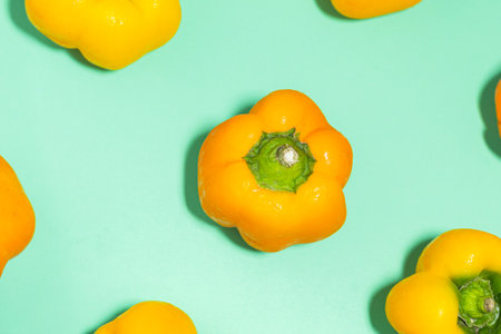 Some fresh yellow bell peppers on an aquamarine background. Top view. Food background. Healthy eating concept.の写真素材