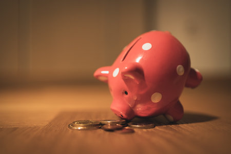 A piggy bank with coins on the floor. Vintage style retro.の写真素材