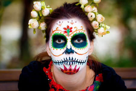 Young women with face painted as fashionable skull for Mexican holiday Day of the Dead.の写真素材