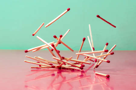 Dropping matches on a pink tableの写真素材