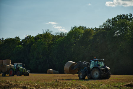 Agricultural machinery in the field. Tractor with hay balesの写真素材