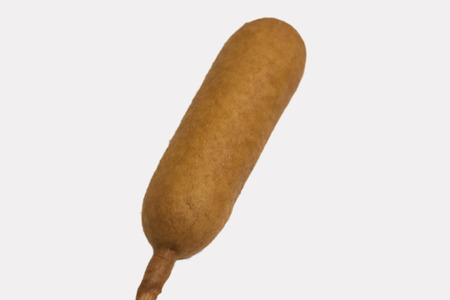 An isolated corn dog at an angle on white background.の写真素材
