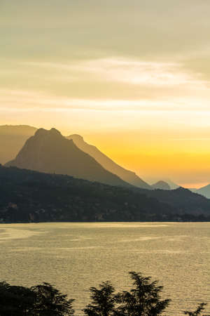 Lake Garda, Italy. peaceful sunset looking out over the lake from Maraschina toward the mountainsの写真素材